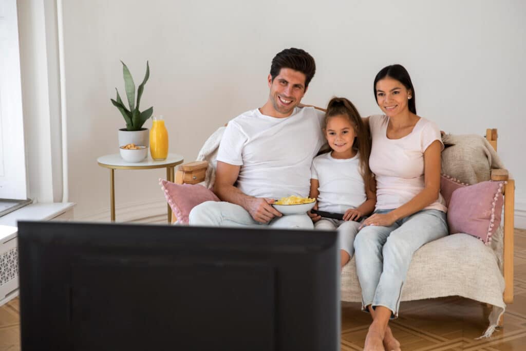 Famille heureuse dans son salon devant la télé